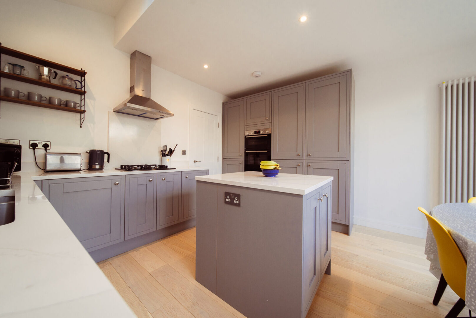 Kitchen with a large island in the middle of it, featuring a sink, tap, gas stove, kettle, toaster