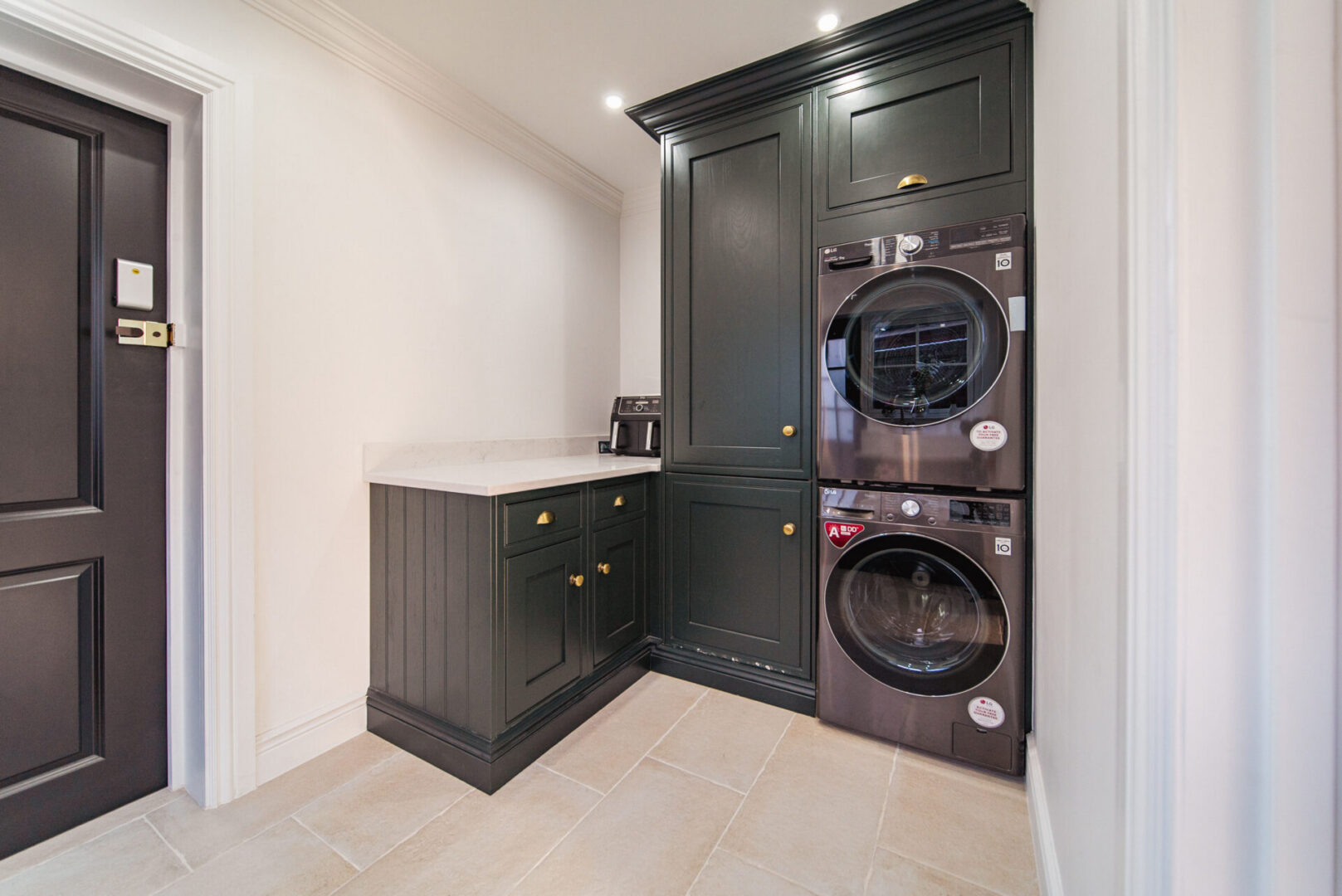 Small laundry room with a washer and dryer, a platform with cupboards, a door on the left side