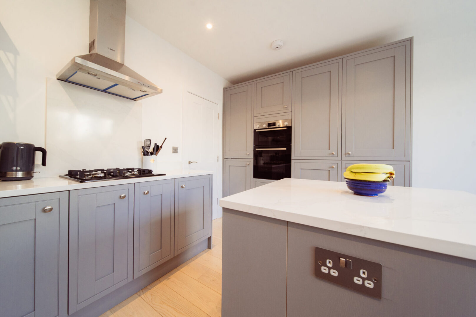 Kitchen with grey cabinets and white counter tops