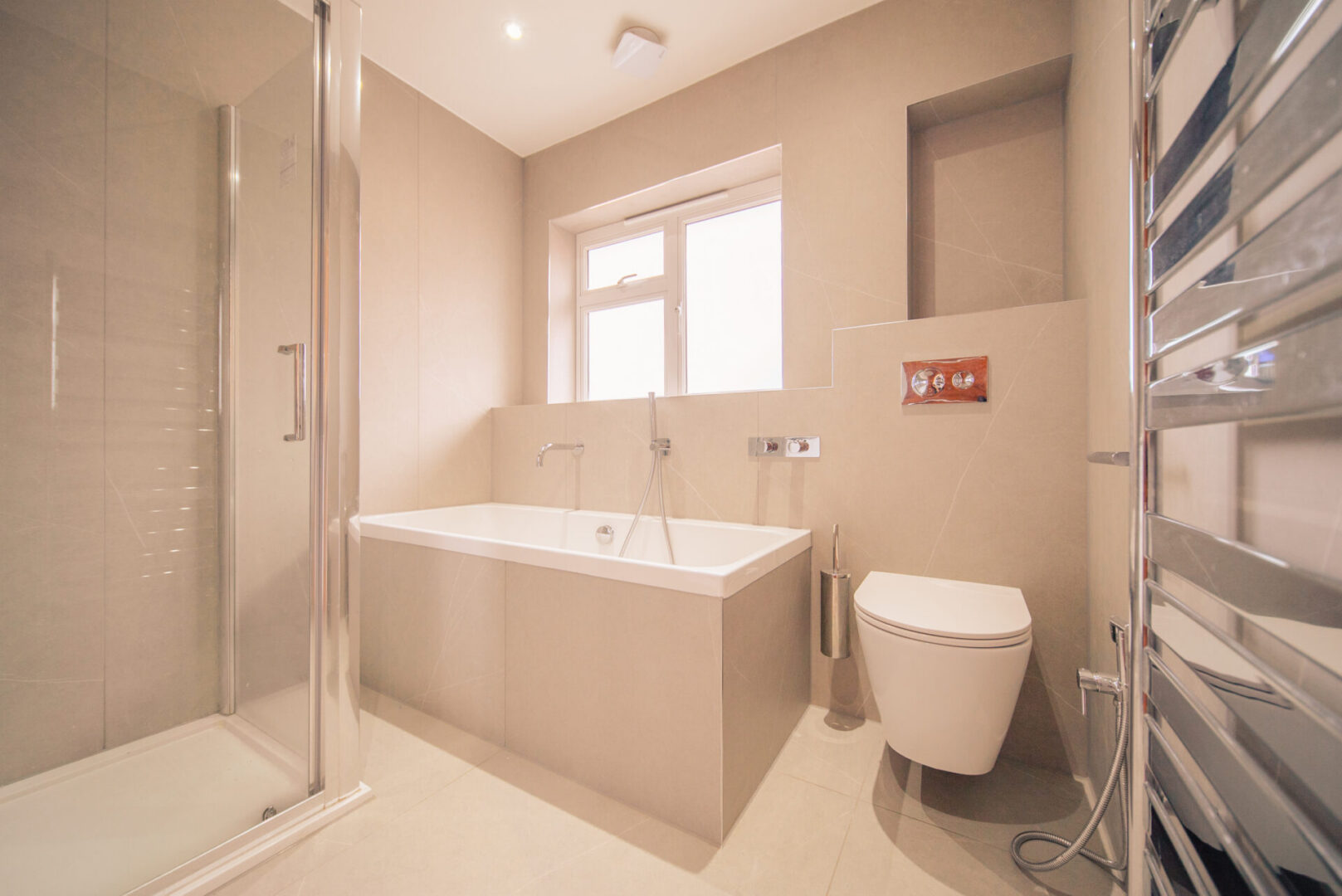 Bathroom with a toilet, bathtub, shower, taps, window, wall, lights and other objects